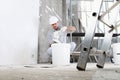 Plasterer man at work, take the mortar from the bucket to plastering the wall of interior construction site wear helmet and Royalty Free Stock Photo