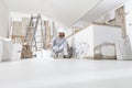 Plasterer man at work, take the mortar from the bucket with trowel to plastering the wall of interior construction house site and Royalty Free Stock Photo