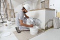 Plasterer man at work, take the mortar from the bucket with trowel to plastering the wall of interior construction house site and Royalty Free Stock Photo