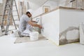 Plasterer man at work, take the mortar from the bucket with trowel to plastering the wall of interior construction house site and Royalty Free Stock Photo