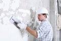 Plasterer man at work with trowel plastering the wall of interior construction site wear helmet and protective gloves, Royalty Free Stock Photo