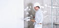 Plasterer man at work with trowel plastering the wall of interior construction site wear helmet and protective gloves, scaffolding Royalty Free Stock Photo