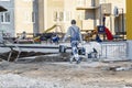 A plasterer or painter worker in dirty work clothes at a construction site. A male worker carries a tool Royalty Free Stock Photo