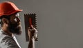 Plasterer renovating wall. Profile of bearded builder. Worker with plastering tools. Renovating house concept. Builder Royalty Free Stock Photo