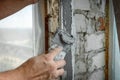 The plasterer repairs the corners of the window with a spatula and plaster. Construction finishing works