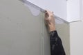 The plasterer`s hand places a corner iron on a wall