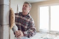 Plasterer smoothing interior wall of new homes with machine Royalty Free Stock Photo