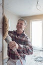 Plasterer smoothing interior wall of new homes with machine Royalty Free Stock Photo