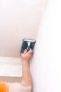 Plasterer smooths the walls with sandpaper close-up. Male hand of a worker. Stock photo Royalty Free Stock Photo