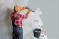 Plasterer with a spatula, the process of applying a layer of putty.