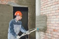 Plasterer spraying plaster on wall Royalty Free Stock Photo