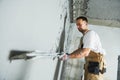 Plasterer using screeder spraying putty plaster mortar on wall Royalty Free Stock Photo