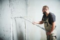 Plasterer using screeder spraying putty plaster mortar on wall Royalty Free Stock Photo