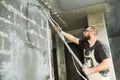 Plasterer using screeder spraying putty plaster mortar on wall Royalty Free Stock Photo