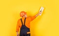 Plasterer in working uniform plastering wall indoor. man with spatula. process of applying layer of putty. Plastering Royalty Free Stock Photo