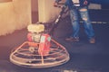 Plasterer working using scrubber machine for cement floor with v