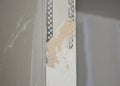 Plastering drywall corner: A close-up on plastering a drywall partition wall over installed angle beads during house renovation Royalty Free Stock Photo