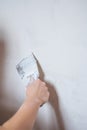 Plastering man hand with plaste and plaster spatula trowel in wall Royalty Free Stock Photo