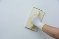 plastering man hand sanding the plaster in white wall Royalty Free Stock Photo