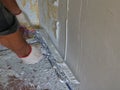plastering the wall with a wide trowel and elastic putty
