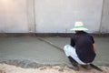 The tiler is working to smooth the cement surface.