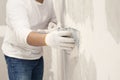 Plasterwork and wall painting preparation. Asian male applying filling drywall patch