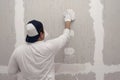 Plasterwork and wall painting preparation. Asian male applying filling drywall patch