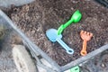 Plastic agriculture tools like harrow and shovel put in black soil in metal cart ready to used for kid learning