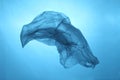 Plastic bag in blue water, garbage under water, plastic pollution of the oceans Royalty Free Stock Photo