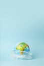 Plastic bag pollution concept. Earth globe in a plastic bag on a colored background. Plastic and waste pollution oceans, nature Royalty Free Stock Photo