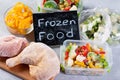 Plastic bags and containers with different frozen vegetables and meat on table, top view Royalty Free Stock Photo