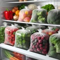 Plastic bags with deep frozen vegetables on white shelves in the refrigerator Royalty Free Stock Photo