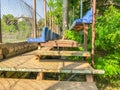 Plastic benches and flowering trees in the city park. Iron steps rise to the podium in the vicinity of the stadium.