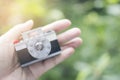 Plastic blocks building create a camera toy is in Asain woman hand with bokeh green tree background,