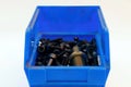 Plastic blue container with bolts on white background. Plastic box for fasteners. Royalty Free Stock Photo