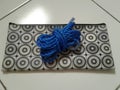 A plastic blue rope on a black and white pencilcase