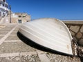 Plastic boat lying bottom up in the cobbled street of Trapani