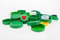 A plastic bottle caps, one cap with heart image isolated on white. Recycling collection plastic caps. Royalty Free Stock Photo