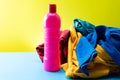 Plastic bottle of cleaning products with pile colorful clothes on table background Royalty Free Stock Photo