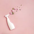 Plastic bottle with cleaning spray and flowers on pink background. Royalty Free Stock Photo