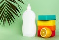 Plastic bottle of dishwashing liquid, lemon and sponges on color background. Washing and cleaning concept Royalty Free Stock Photo