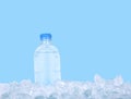 Plastic bottle of drinking water on ice over blue Royalty Free Stock Photo