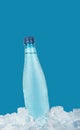 Plastic bottle of drinking water on ice over blue Royalty Free Stock Photo