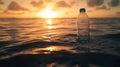 Plastic bottle floating in ocean at sunset with golden clouds. Environmental pollution and conservation concept Royalty Free Stock Photo