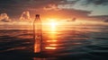 Plastic bottle floating on ocean during vibrant sunset, warm colors. Environmental pollution and ocean conservation Royalty Free Stock Photo