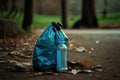 plastic bottle with garbage inside, next to bin and bag in the park Royalty Free Stock Photo