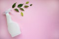 Plastic bottle with liquid for cleaning glass, plumbing, tiles or floor and green herbal leaves on a pink background with space Royalty Free Stock Photo