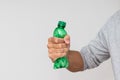 Plastic bottle recycling or pollution concept. Hand squeezing or crushing a green plastic bottle on white background Royalty Free Stock Photo
