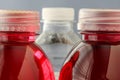 Plastic bottle with red non alcoholic drink and clear water in plastic bottle in back Royalty Free Stock Photo