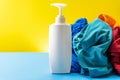 Plastic bottles of cleaning products set with pile clothes on blue table Yellow background Royalty Free Stock Photo